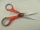 Scissors with red plastic handle